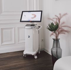 Scannereinheit CEREC Primescan im Behandlungszimmer Blumenvase im Vordergrund